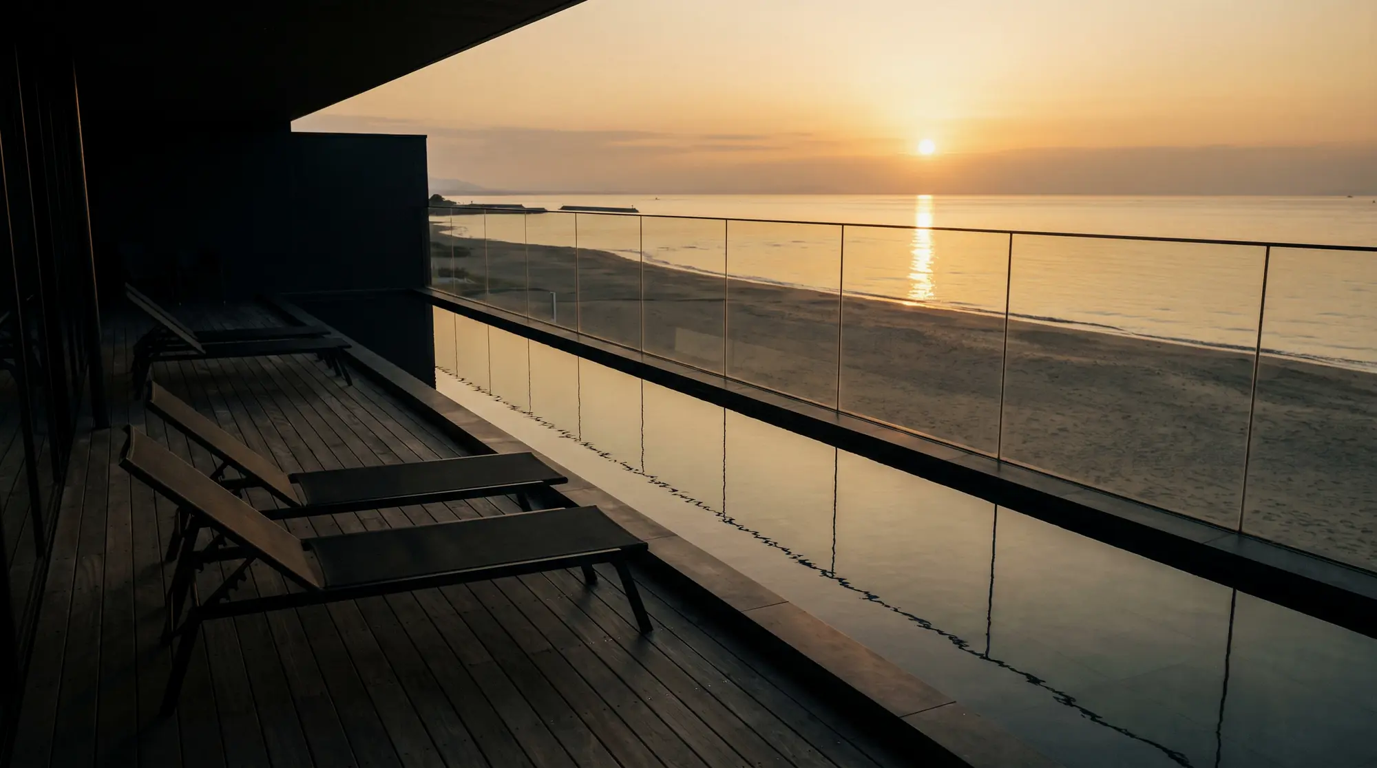 砂浜に面した2階のバルコニーとデッキチェア、夕日(イメージ)
